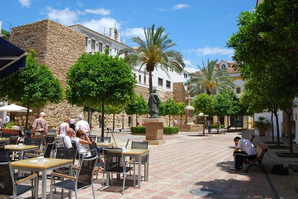 Chodník kavárna na náměstí kostela s hradní zdí vzadu, Marbella, Španělsko. — Stock fotografie