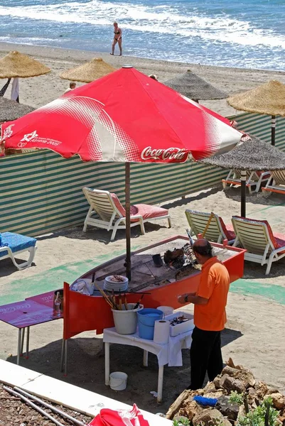 Cocinero cocinando sardinas en un barco de barbacoa en la playa de Daitona, Marbella, España . — Foto de Stock