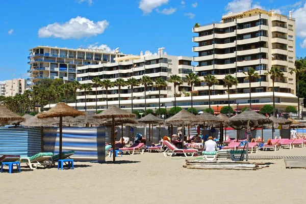 Turiștii care se relaxează pe plaja Daitona cu hoteluri și apartamente în spate, Marbella, Spania . — Fotografie, imagine de stoc