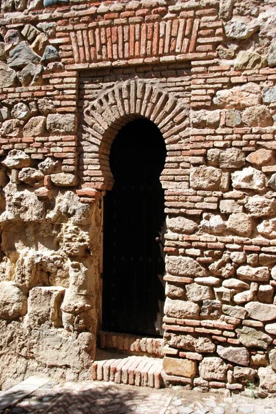 Puerta estrecha y arqueada fuera del patio de proveedores en el castillo de Málaga, Málaga, España . — Foto de Stock