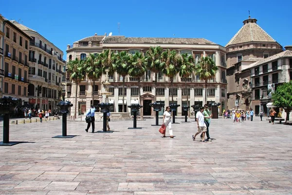 Kilátás a törzs szobrok Alkotmány tér az emberek élvezik a beállítást, Malaga, Spanyolország. — Stock Fotó