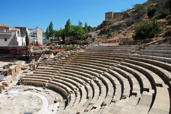 View of the Roman Amphitheatre in the city centre overlooked by the castle to the right, Malaga, Spain. — Stock Photo, Image