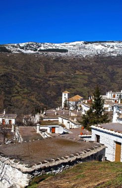 General view over town rooftops featuring the unique flat grey rooves with tall chimneys, Bubion, Las Alpujarras, Granada Province, Andalucia, Spain. clipart