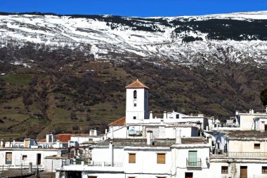 Şehrin çatılarına bakın. Kilisemizin baş rahibesine doğru. Sierra Nevada, Capileira, Las Alpujarras, Granada Eyaleti, Endülüs, İspanya, Batı Avrupa 'nın karlı dağlarına doğru..