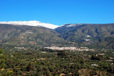 View of the town and countryside in the Vale of Lecrin with views towards the snow capped Sierra Nevada mountains, Orgiva, Vale of Lecrin, Las Alpujarras, Granada Province, Andalusia, Spain, Western Europe. clipart