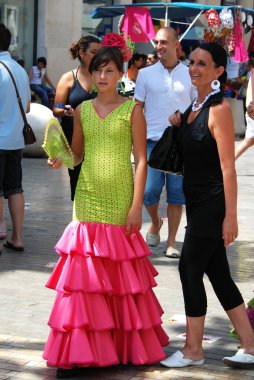 Malaga, İspanya - 18 Ağustos 2008 - Malaga, İspanya - 18 Ağustos 2008 'de Malaga Panayırı' nda Calle Marques de Larios boyunca flamenko elbiseli genç bir kadın