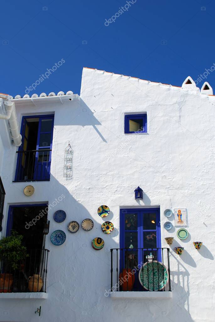 Pretty ceramic plates on a townhouse wall in a whitewashed village (pueblo blanco), Frigiliana, Costa del Sol, Malaga Province, Andalucia, Spain.