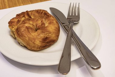 Kaşık ve çatalla beyaz tabakta beyaz peynirli Türk gülü pastası (borek) yemeye hazır olun.