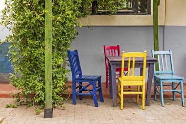 Pergola 'da masa ve renkli sandalyeler
