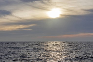 Dalgalı deniz ve gün batımında ufuk çizgisi