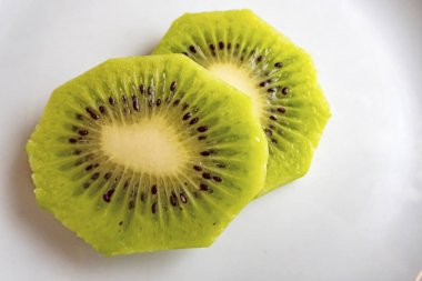 Dilimlenmiş kivi meyveleri beyaz tabakta