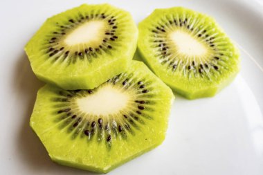 Dilimlenmiş kivi meyveleri beyaz tabakta