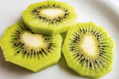 Dilimlenmiş kivi meyveleri beyaz tabakta