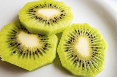 Dilimlenmiş kivi meyveleri beyaz tabakta