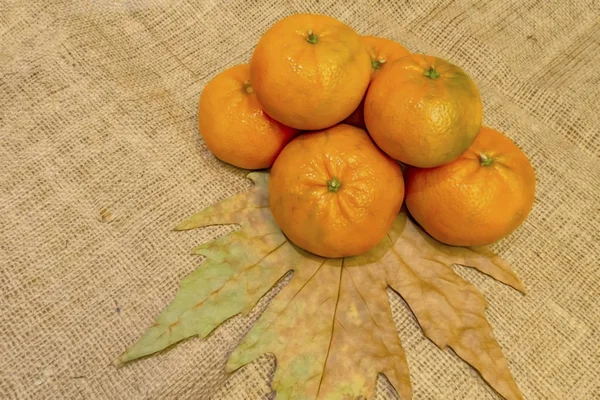 Sonbahar Yaprakları Hasır Arka Planda Mandarin Meyvelerini Kapat — Stok fotoğraf