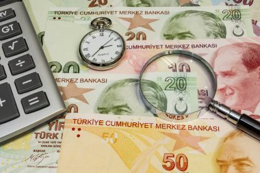 Türk lira banknotlarını saat, büyüteç ve hesap makinesiyle kapat