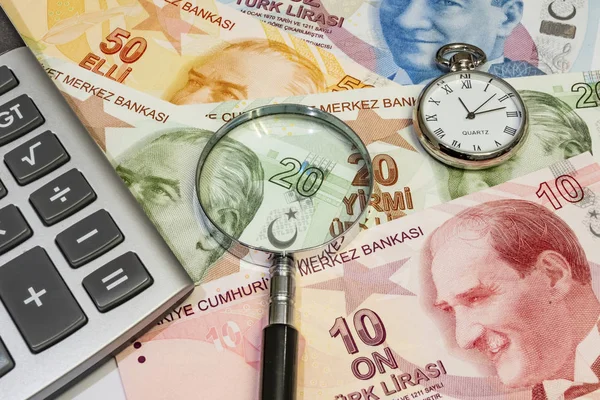 Türk lira banknotlarını saat, büyüteç ve hesap makinesiyle kapat