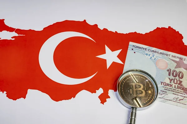 Bitcoin madeni para ve büyüteçle arka planda Türk lira banknotlarını kapat