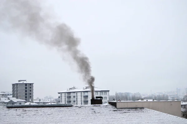 Un día de invierno, y chimenea de humo negro —  Fotos de Stock