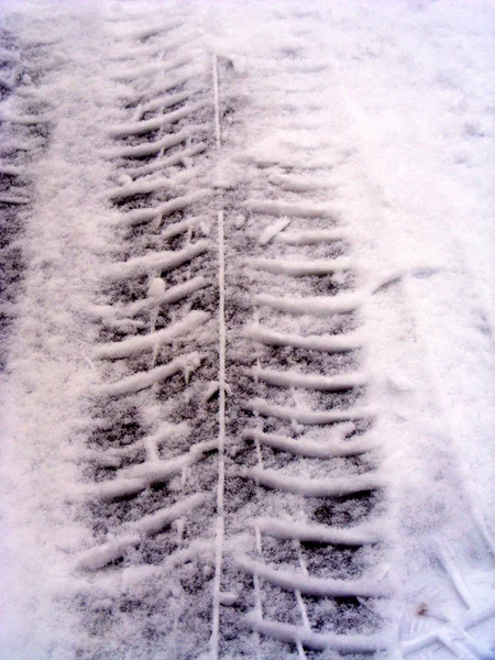 car tire tracks in the snow and