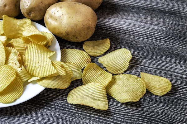 Aardappelen en aardappelproducten, plakjes gebakken aardappel, plakjes aardappel gekarteld, gebakken aardappel vlokken in een oven gebakken, — Stockfoto