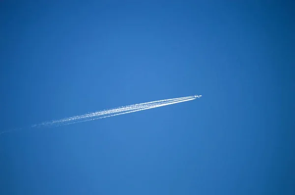 Το αεροπλάνο στον ουρανό και το σύμπλεγμα των νεφών που άφησε, το αεροπλάνο στο μπλε του ουρανού, και το σύμπλεγμα των νεφών που αφήνει. — Φωτογραφία Αρχείου