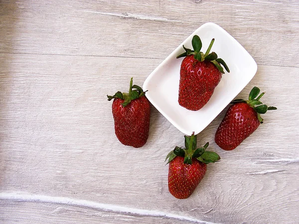 Fresas en el suelo rústico, fresas en el plato, hermosas fotos de fresas , — Foto de Stock