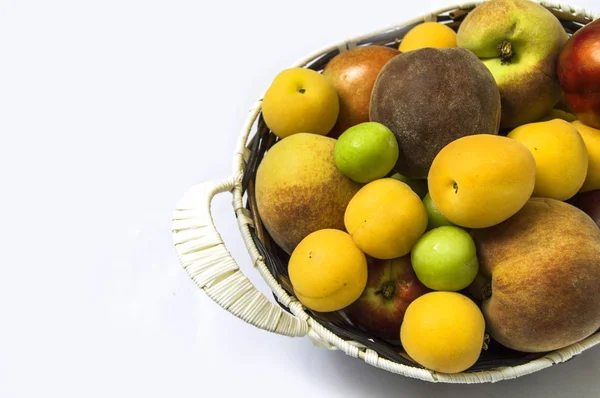 Photos de fruits d'été mixtes dans un panier, fond blanc avec un panier de pêches, prunes, pommes, nectarines, abricots images — Photo