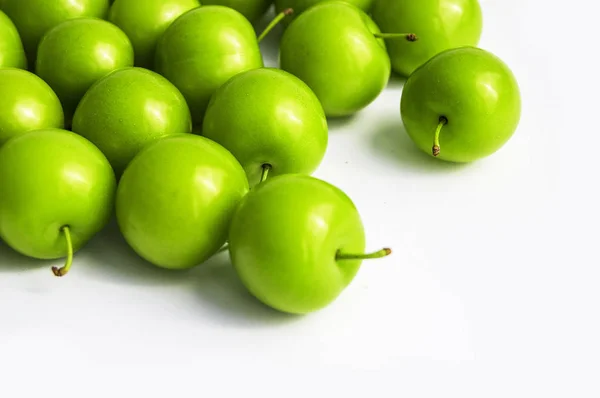 Qualité et vie naturelle donnant des plumes aigres vertesPrunes aigres vertes dans la plaque, photos de prunes sur le fond blanc , — Photo