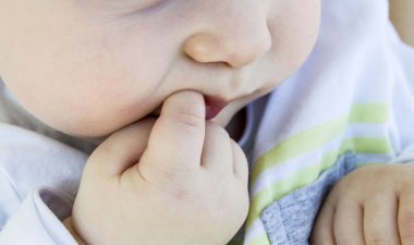 Bebeğin diş çekimi ve parmak resimler emme,