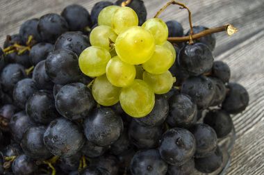 Bir ahşap zemin üzerinde siyah üzüm, siyah ve Yeşil üzüm resimleri plaka, büyük siyah üzüm resimleri