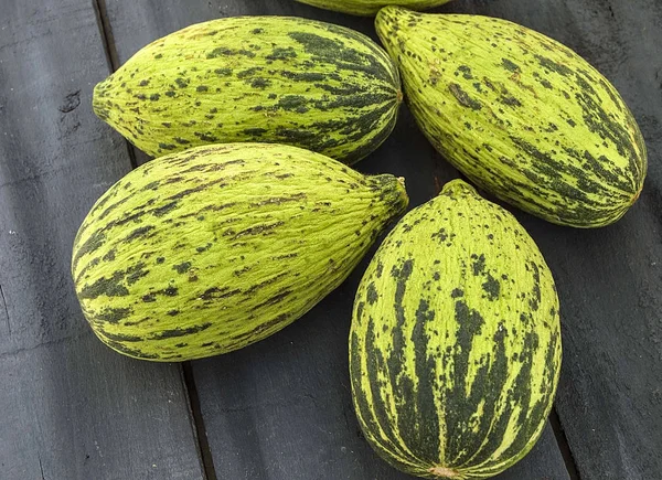 küçük kavun bir bıçak ile kesmek, olgunlaşmamış bir yemek kavun, olgunlaşmamış küçük kavun,