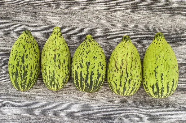 küçük kavun bir bıçak ile kesmek, olgunlaşmamış bir yemek kavun, olgunlaşmamış küçük kavun,