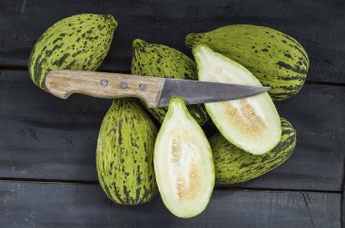 küçük kavun bir bıçak ile kesmek, olgunlaşmamış bir yemek kavun, olgunlaşmamış küçük kavun,