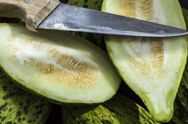 küçük kavun bir bıçak ile kesmek, olgunlaşmamış bir yemek kavun, olgunlaşmamış küçük kavun,