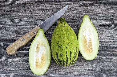 küçük kavun bir bıçak ile kesmek, olgunlaşmamış bir yemek kavun, olgunlaşmamış küçük kavun,