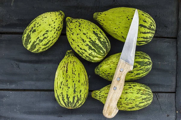 küçük kavun bir bıçak ile kesmek, olgunlaşmamış bir yemek kavun, olgunlaşmamış küçük kavun,