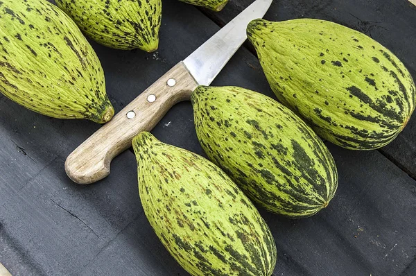 küçük kavun bir bıçak ile kesmek, olgunlaşmamış bir yemek kavun, olgunlaşmamış küçük kavun,