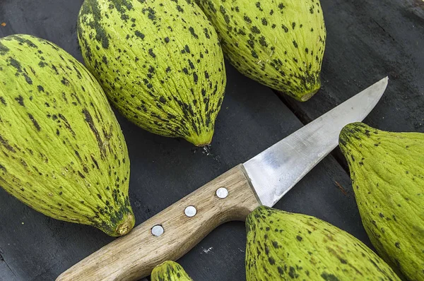 küçük kavun bir bıçak ile kesmek, olgunlaşmamış bir yemek kavun, olgunlaşmamış küçük kavun,