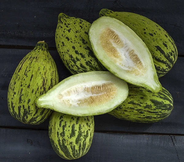 küçük kavun bir bıçak ile kesmek, olgunlaşmamış bir yemek kavun, olgunlaşmamış küçük kavun,