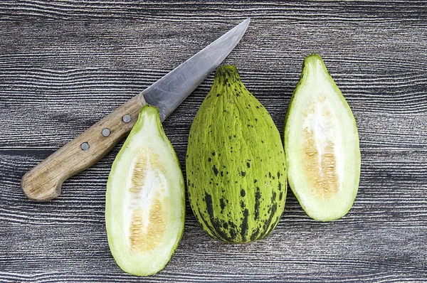 küçük kavun bir bıçak ile kesmek, olgunlaşmamış bir yemek kavun, olgunlaşmamış küçük kavun,