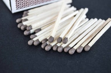 siyah bir arka plan ile bir kibrit kutusu ve bu maçta düzinelerce vardır,