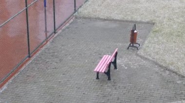 Yağan kar ve pembe boş koltuk, kışın parkta koltuk.,