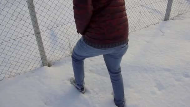Ένα Άτομο Που Περπατάει Στο Χιόνι Και Ένα Συρματόπλεγμα — Αρχείο Βίντεο