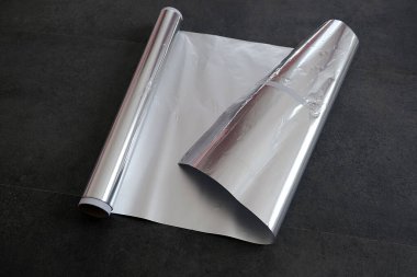 Alüminyum folyo, rulo alüminyum folyo, siyah arka planda yakın plan.,