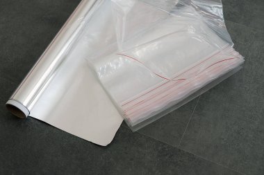 Alüminyum folyo ve buzdolabı çantası, siyah zeminde.,