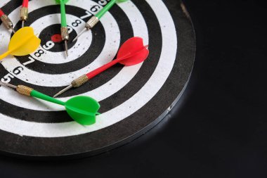 dart sporu dalı, dart tahtası ve siyah zeminde renkli dart okları