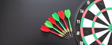 kırmızı, sarı, yeşil oklar ve dart tahtası, siyah arkaplanda