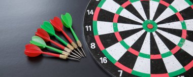 kırmızı, sarı, yeşil oklar ve dart tahtası, siyah arkaplanda