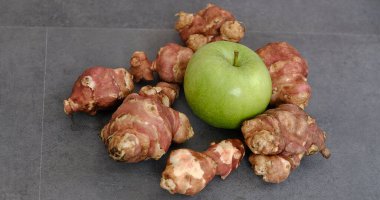 Kudüs enginarı ve kara zeminde yeşil elma.,